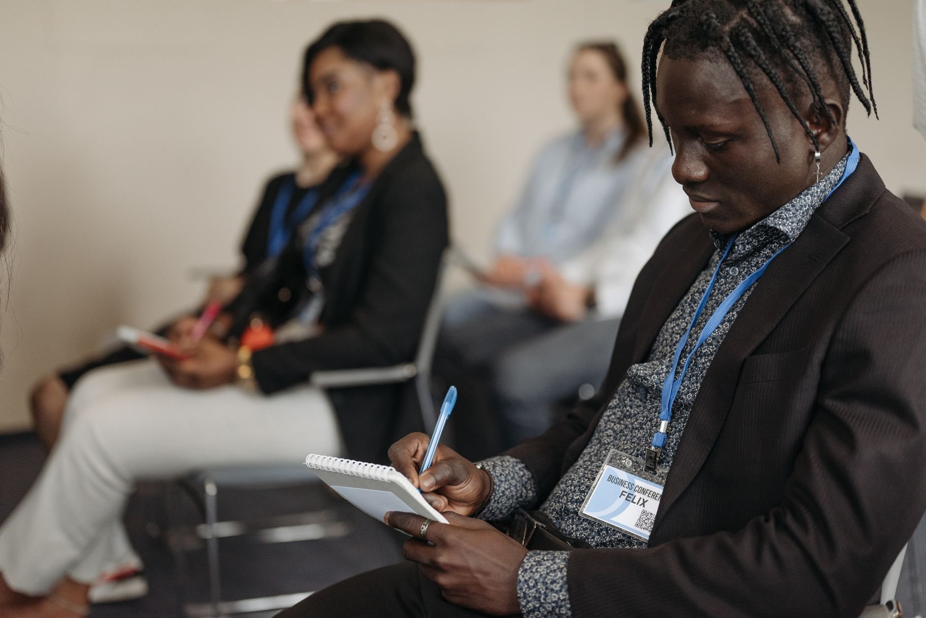 A diverse group of adults attentively participating in a training workshop, taking notes and engaging.